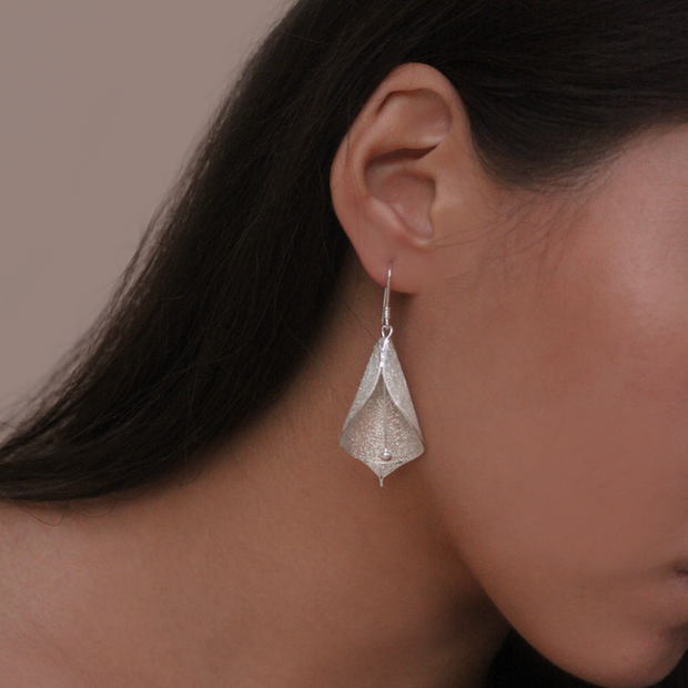 On model, silver Liryo Calla Lily Drop Earrings